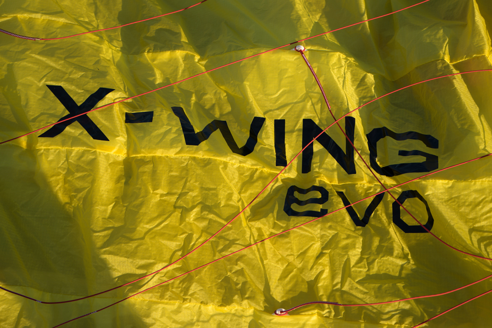 Gelber X-Wing-Evo-Schirm mit roten Leinen am Boden